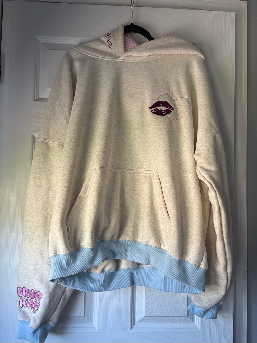 Cream Crewneck Hoodie with Light Blue Trim and Purple Lip Detail